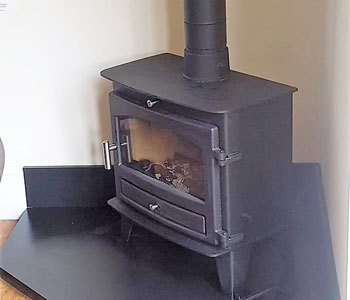 Avalon Slimline 8 Multi-Fuel Stove - fitted by our own installers with internal system chimney and corner shaped slate hearth in Banstead, near Epsom, Surrey.